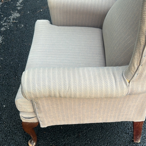 91 - Upholstered beige wingback armchair with curved wooden legs. Vintage style.