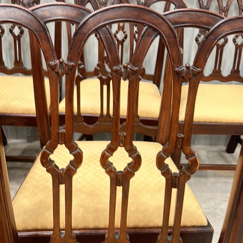 274 - Set of eight mahogany dining chairs with intricately carved backs and upholstered seats, featuring a... 