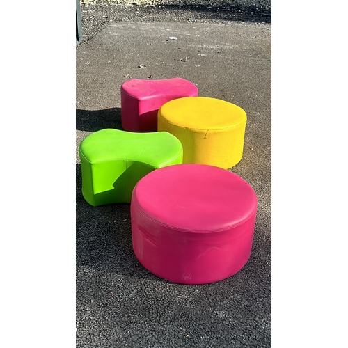 280 - Set of four vibrant cylindrical ottomans in pink, green, and yellow, upholstered in durable fabric.