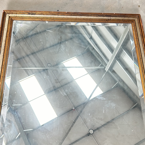 304 - Large square mirror with a gilt wooden frame and a beveled edge. The frame displays a classic design... 