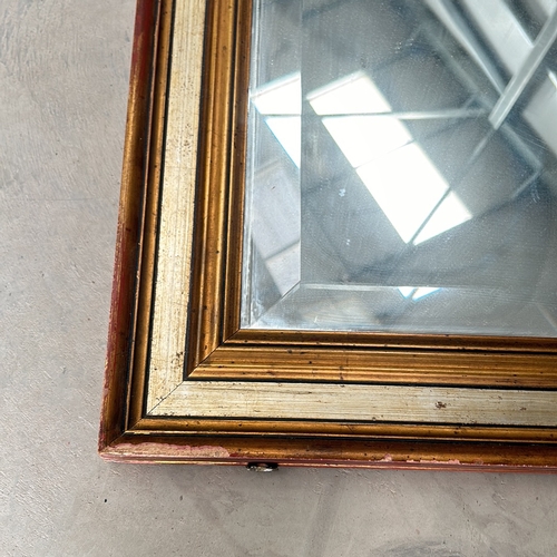 304 - Large square mirror with a gilt wooden frame and a beveled edge. The frame displays a classic design... 