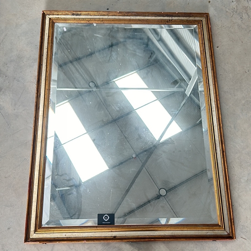 304 - Large square mirror with a gilt wooden frame and a beveled edge. The frame displays a classic design... 