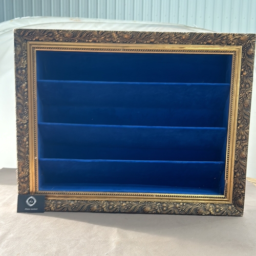 311 - Ornate gold-tone framed shadow box with deep blue velvet lining and shelves.