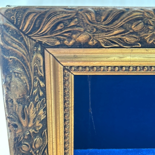 311 - Ornate gold-tone framed shadow box with deep blue velvet lining and shelves.