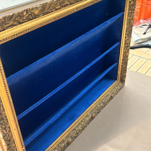 311 - Ornate gold-tone framed shadow box with deep blue velvet lining and shelves.