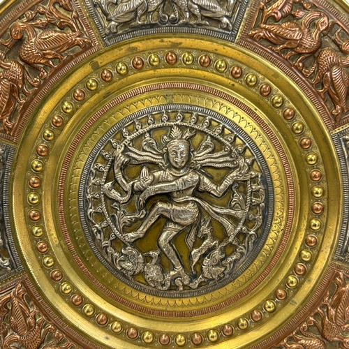 156 - An Indian mixed metal tray.Relief decorated central silver roundel depicting Shiva. Bordered with si... 