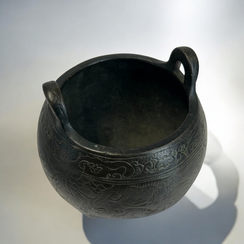 228 - A Chinese bronze tripod censer.Globular form, engraved with various scenes, including a warrior on h... 