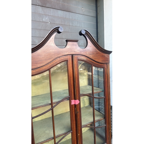 364 - Mahogany display cabinet with glass doors, curved pediment, and decorative inlay. Approximately 200 ... 