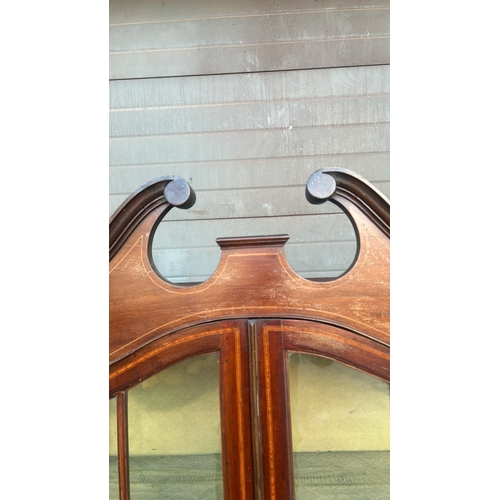 364 - Mahogany display cabinet with glass doors, curved pediment, and decorative inlay. Approximately 200 ... 