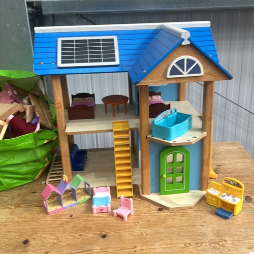 375 - Wooden dollhouse with solar panel design, featuring two floors and vibrant furniture pieces. Approxi... 