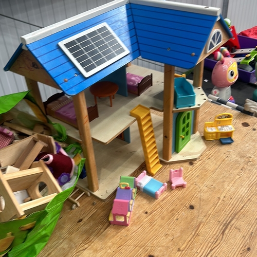 375 - Wooden dollhouse with solar panel design, featuring two floors and vibrant furniture pieces. Approxi... 