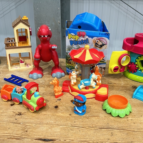 407 - Assorted plastic playset including carousel, dinosaur, train, and houses. Includes Pop-Up Pirate gam... 