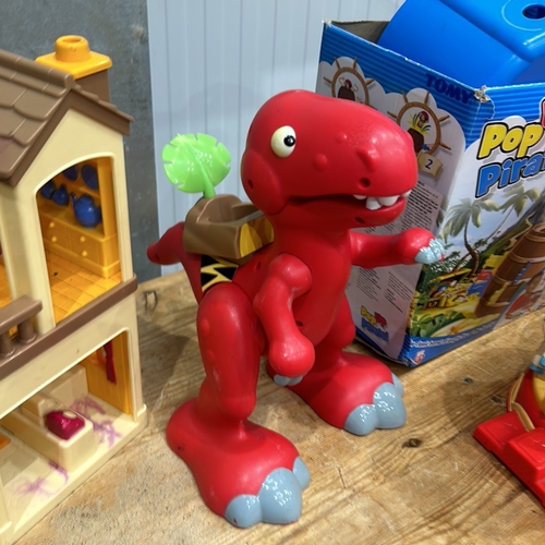 407 - Assorted plastic playset including carousel, dinosaur, train, and houses. Includes Pop-Up Pirate gam... 