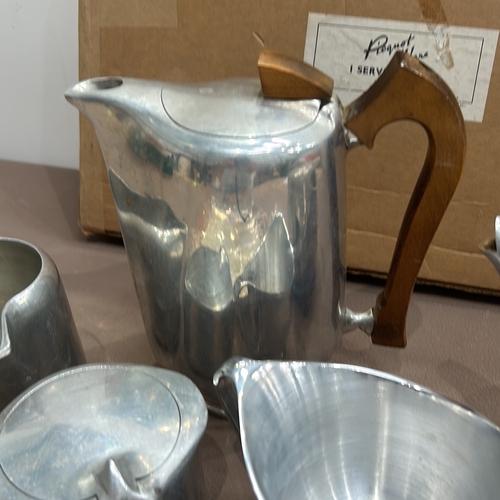 399 - Regent Piquot Ware aluminium tea set, featuring a teapot with wooden handle, creamer, and sugar bowl... 