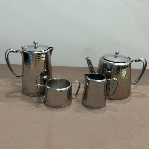 401 - Four-piece hammered silver plate tea set by Old HAll, including a teapot, coffee pot, creamer, and s... 