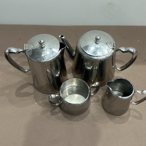 401 - Four-piece hammered silver plate tea set by Old HAll, including a teapot, coffee pot, creamer, and s... 