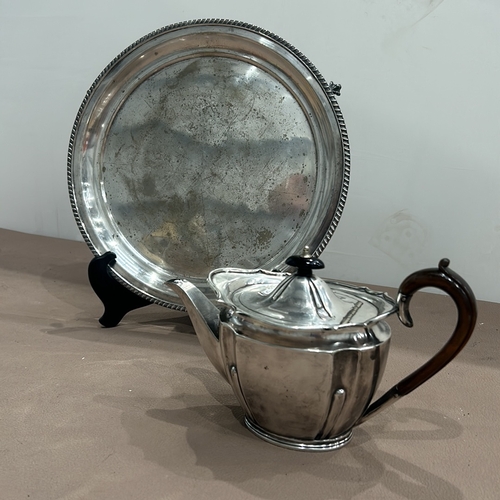 403 - Silver plated teapot by Gibson and Co. with wooden handle, accompanied by a round silver plated tray... 