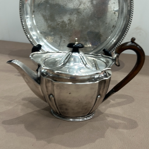 403 - Silver plated teapot by Gibson and Co. with wooden handle, accompanied by a round silver plated tray... 