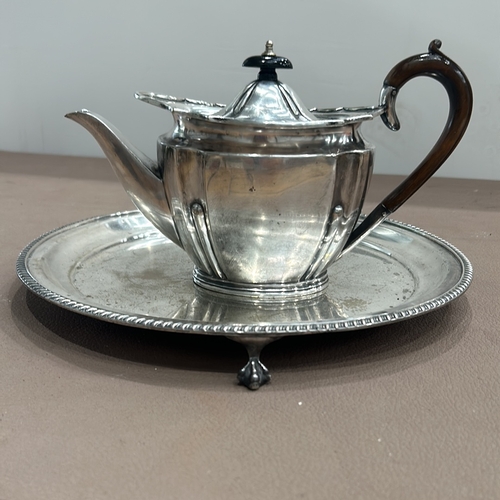 403 - Silver plated teapot by Gibson and Co. with wooden handle, accompanied by a round silver plated tray... 