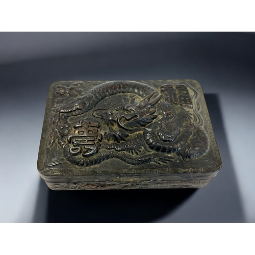 274 - A Chinese embossed metal trinket box.Early 20th century.Relief decorated with a entwined Dragon. Ins... 