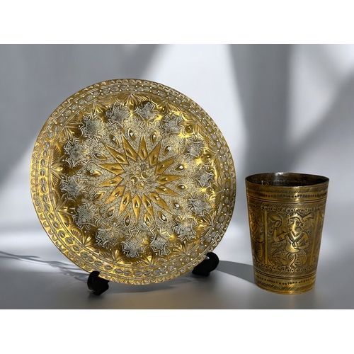 389 - An engraved Indian brass Lassi cup, together with an embossed brass tray.