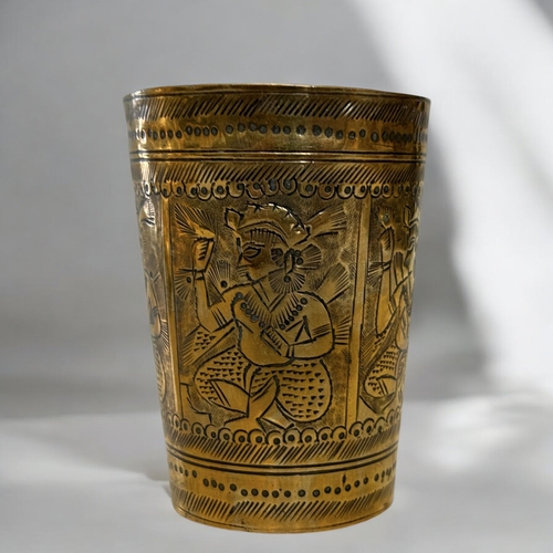 389 - An engraved Indian brass Lassi cup, together with an embossed brass tray.