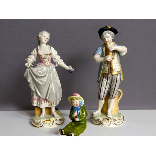 287 - A pair of German porcelain hand painted figures.Marks to base. Together with a Ernst Bohn seated fig... 