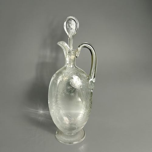 393 - A 19th century engraved glass claret jug.Finely engraved with tropical birds perched in blossoming t... 