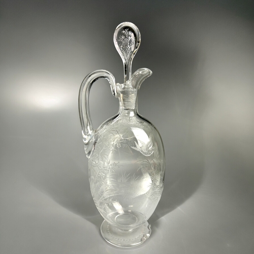 393 - A 19th century engraved glass claret jug.Finely engraved with tropical birds perched in blossoming t... 