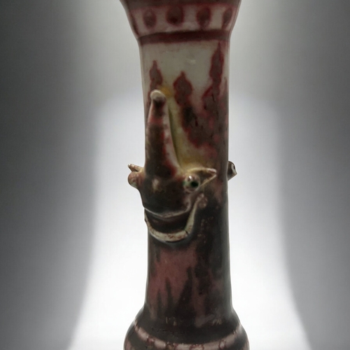 2 - An unusual Chinese porcelain vase.Raised on three masked feet, with iron red glazed, slender taperin... 