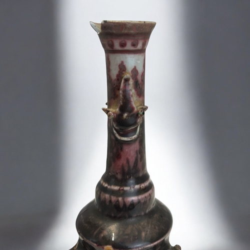 2 - An unusual Chinese porcelain vase.Raised on three masked feet, with iron red glazed, slender taperin... 