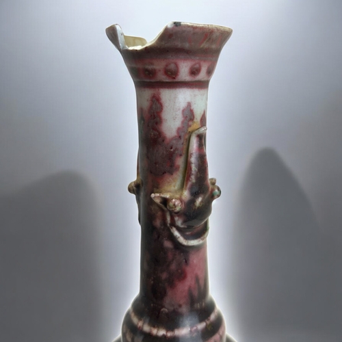 2 - An unusual Chinese porcelain vase.Raised on three masked feet, with iron red glazed, slender taperin... 