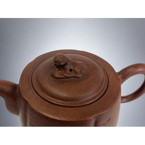 18 - A Chinese Yixing Zisha clay teapot.Incised script & foliate design.Marked to base. 18 x 9cm... 