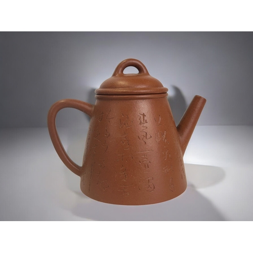 19 - A Chinese Yixing clay teapot.Inscribed script to each side. 11 x 14cm