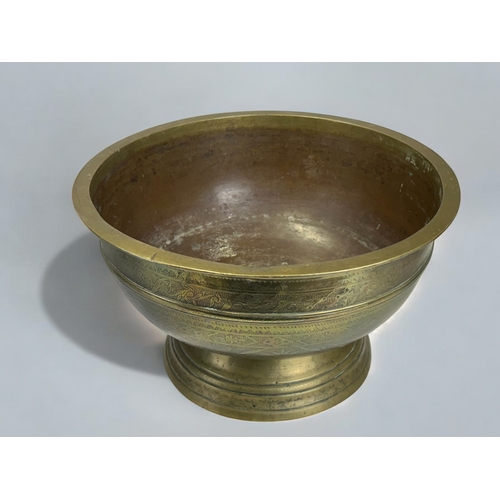 12 - A large cast brass Indonesian ceremonial bowl.Early 19th century, probably Java.Raised on tall foot,... 