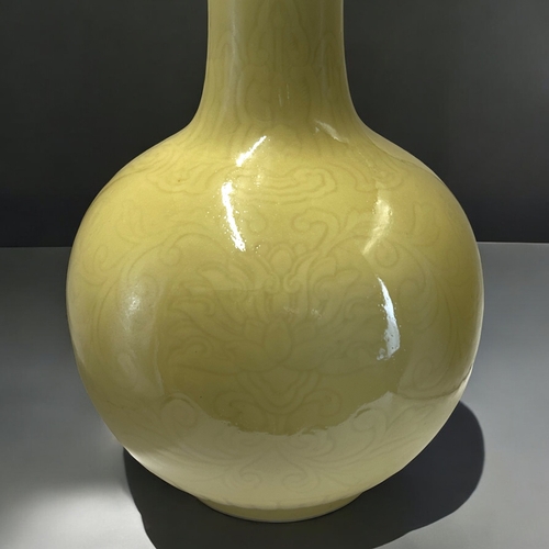 56 - A large Chinese monochrome yellow glaze vase.Bottle shape, incised with Lotus and scrolling foliate ... 