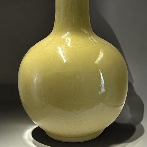 56 - A large Chinese monochrome yellow glaze vase.Bottle shape, incised with Lotus and scrolling foliate ... 