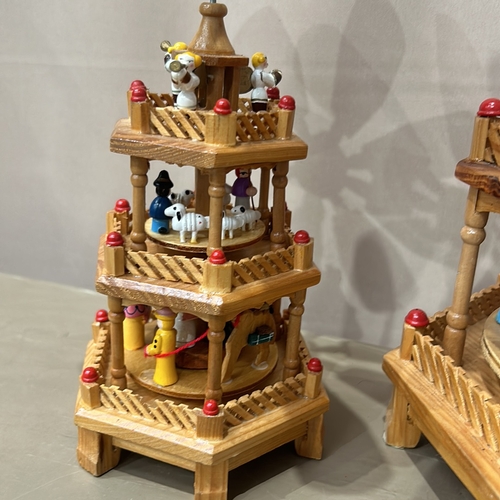 392 - Collection of wooden Christmas pyramids with intricate figures and accessories, displayed alongside ... 