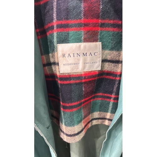 241 - RainMac Midhurst Vyella green rain cape with red plaid lining, featuring button closure and hood.