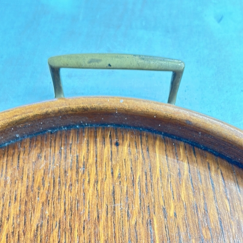 339 - Two Antique oak serving trays, rectangular and oval, featuring brass handles and smooth edges.