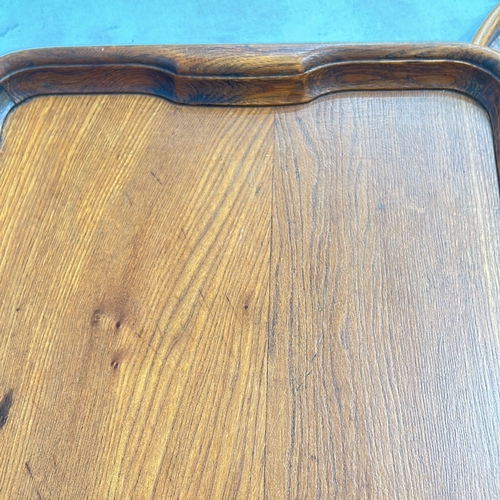 339 - Two Antique oak serving trays, rectangular and oval, featuring brass handles and smooth edges.