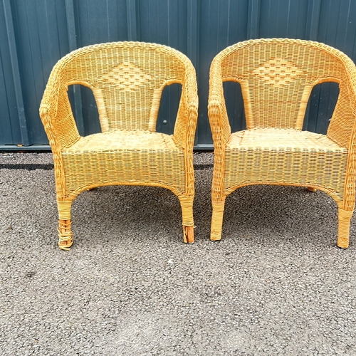 101 - Pair of wicker armchairs with woven detailing and a natural finish.