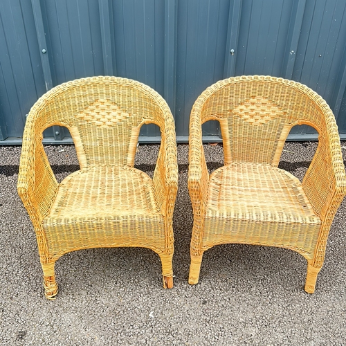 101 - Pair of wicker armchairs with woven detailing and a natural finish.