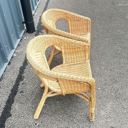 101 - Pair of wicker armchairs with woven detailing and a natural finish.