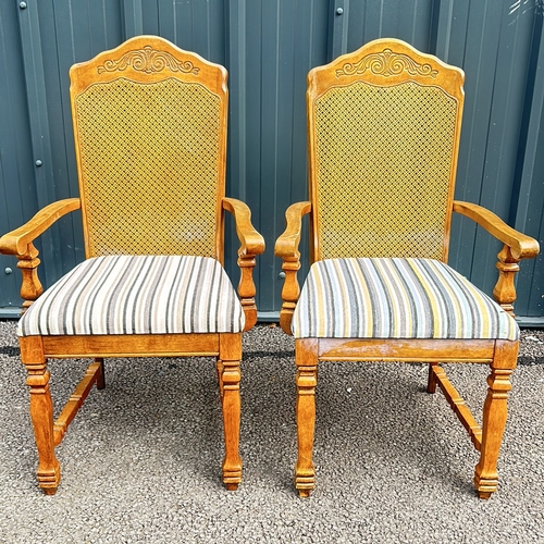 102 - Carved oak armchair with caned back and striped upholstered seat, featuring turned legs. Style is re... 