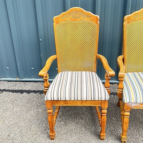 102 - Carved oak armchair with caned back and striped upholstered seat, featuring turned legs. Style is re... 