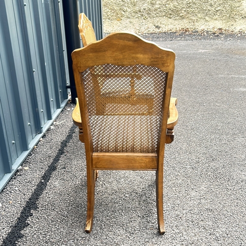 102 - Carved oak armchair with caned back and striped upholstered seat, featuring turned legs. Style is re... 