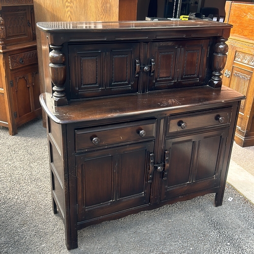 61 - Ercol dark wood sideboard features carved columns and paneled doors, offering ample storage. Ercol