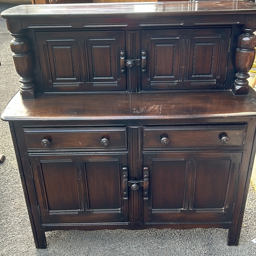 61 - Ercol dark wood sideboard features carved columns and paneled doors, offering ample storage. Ercol