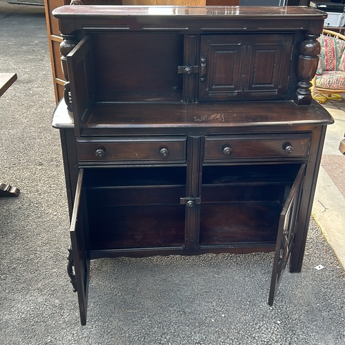 61 - Ercol dark wood sideboard features carved columns and paneled doors, offering ample storage. Ercol